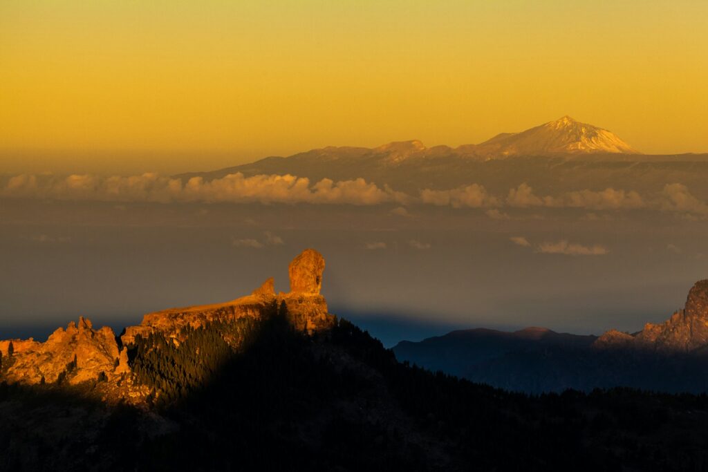 a view of a mountain range with clouds in the foreground
